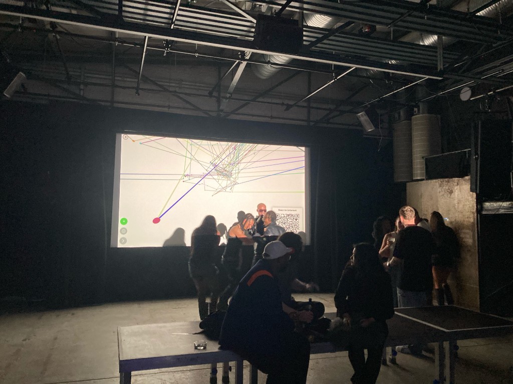 An audience with phones in front of Connect projected at a live event in Berlin.